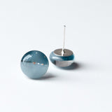 stud earrings containing tiny amounts of beach sand