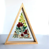 A triangular wooden frame containing a fused glass triangle depicting Australian native blooms such as Waratah, Bottlebrush and Golden Wattle.